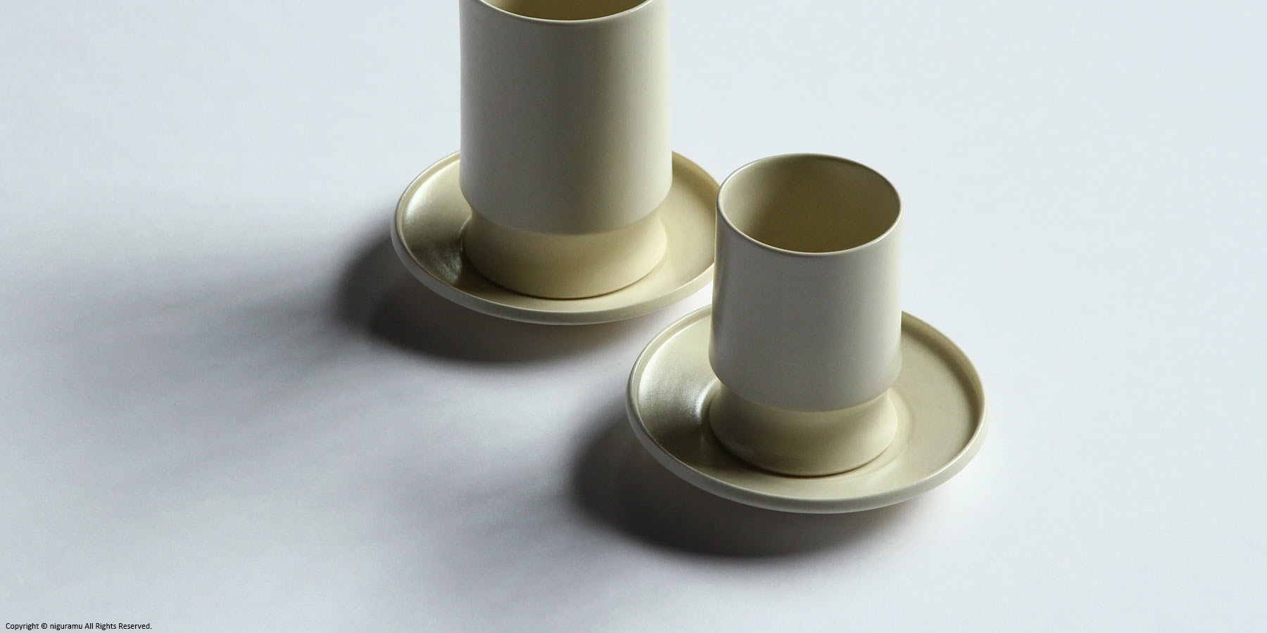 Une, Cup and tumbler on saucers.